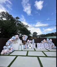 a baby shower set up with pink and blue balloons