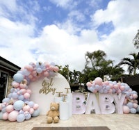 a baby shower with balloons and a teddy bear