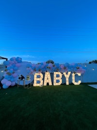 a baby shower with balloons and a sign that says babycc