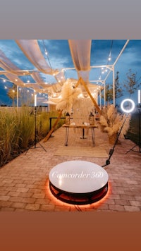 a circular table with lights in the middle of a patio