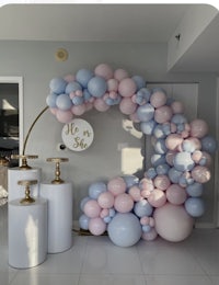 a balloon arch decorated with pink and blue balloons