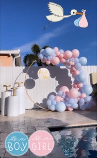 a balloon arch with a stork and balloons